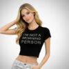 Crop t-shirt Suga Style σε μαύρο χρώμα με ασημί γράμματα “I’M NOT A MORNING PERSON” στο μπροστινό μέρος.