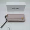 Minimal πορτοφόλι Guess σε nude-ροζ απόχρωση με χρυσές λεπτομέρειες, διπλό κλείσιμο με φερμουάρ και αποσπώμενο strap.