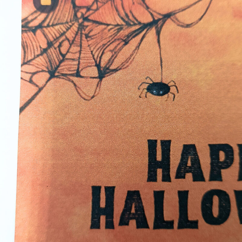 Ευχετήρια κάρτα πορτοκαλί Halloween με ιστούς αράχνης και μαύρο κείμενο “Happy Halloween”
