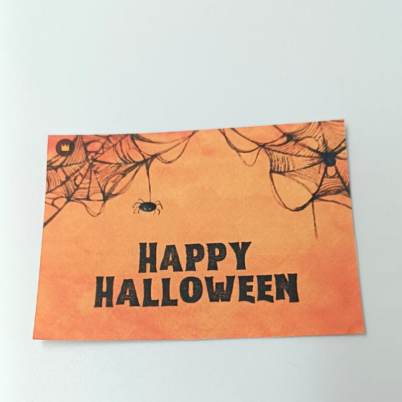 Ευχετήρια κάρτα πορτοκαλί Halloween με ιστούς αράχνης και μαύρο κείμενο “Happy Halloween”