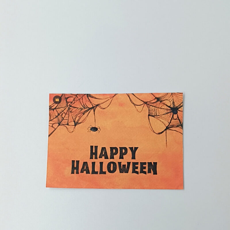 Ευχετήρια κάρτα πορτοκαλί Halloween με ιστούς αράχνης και μαύρο κείμενο “Happy Halloween”